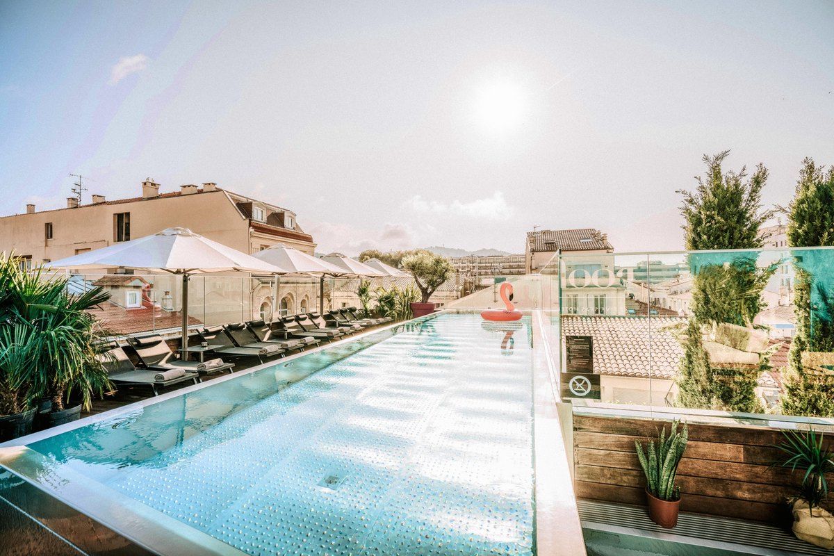 The rooftop pool and loungers of the Lounge Bar by Le Roof on top of the Five Seas Hotel, looking towards Le Suquet