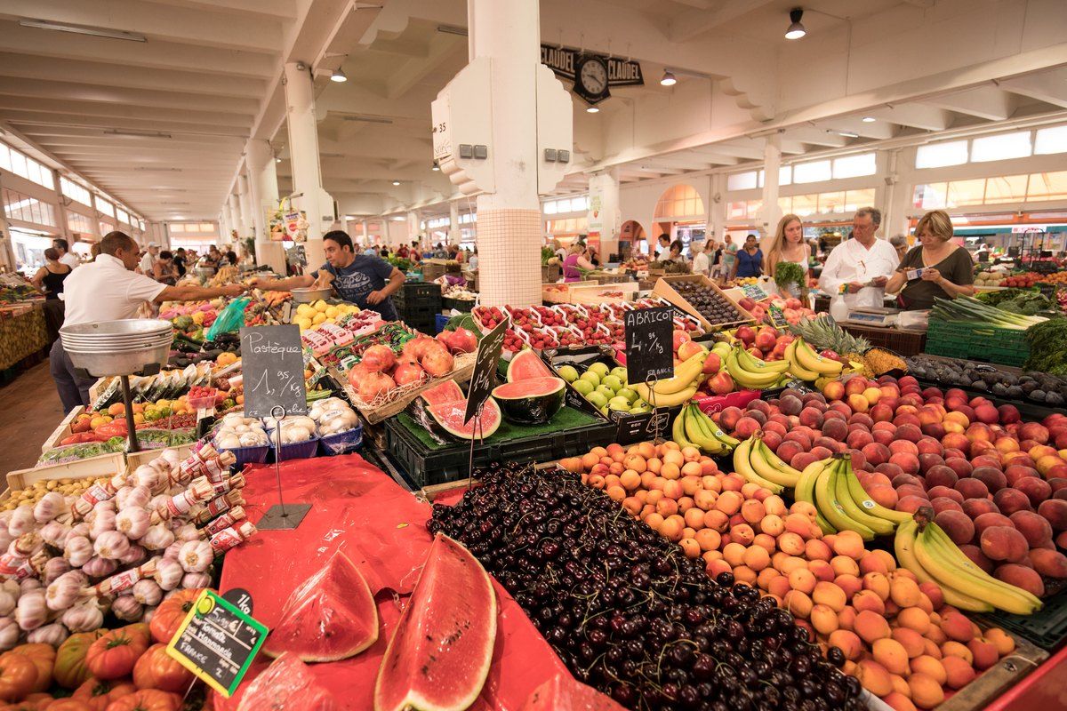 A fruit stall piled with watermelons, peaches, cherries and bananas at the Forville market in Cannes