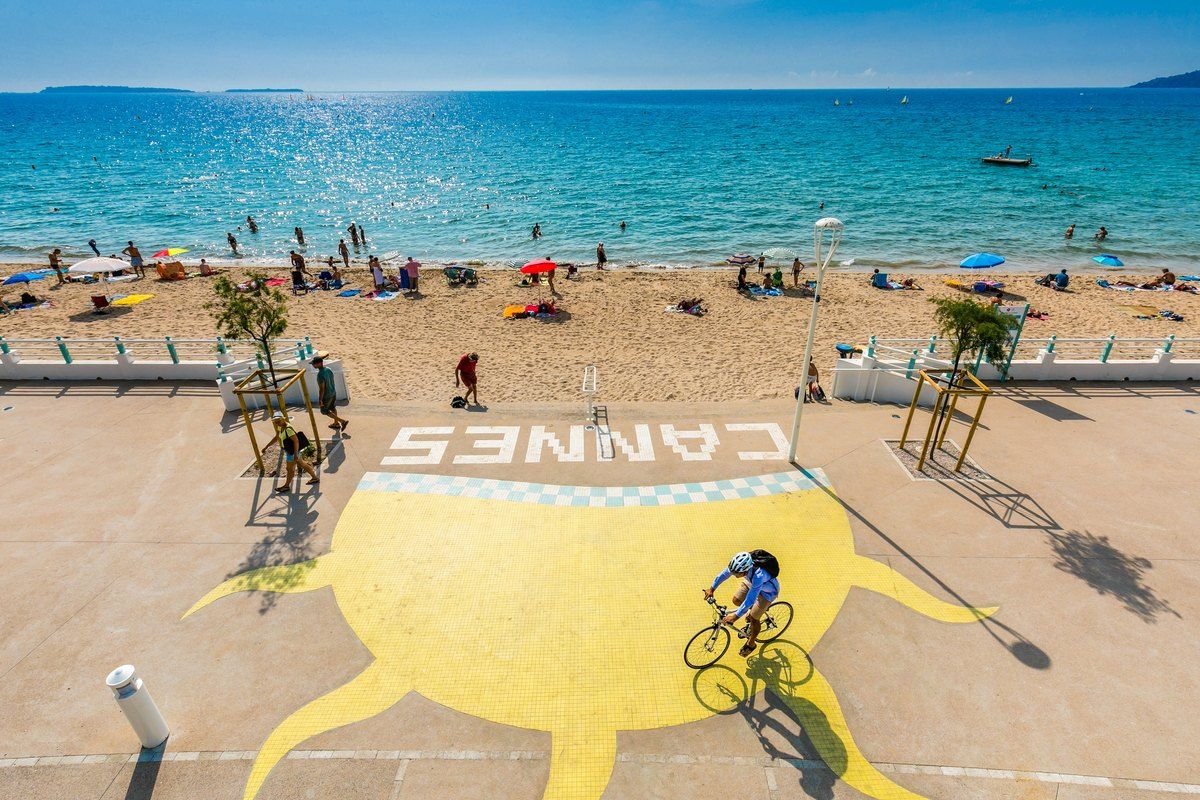The public BoccaCabana beach at Cannes La Bocca, with the Cannes sign on the sand and the bay beyond