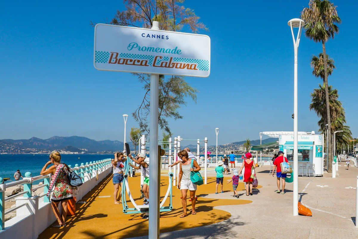 The BoccaCabana seafront promenade in Cannes La Bocca with its sign, palms and outdoor fitness area by the sea