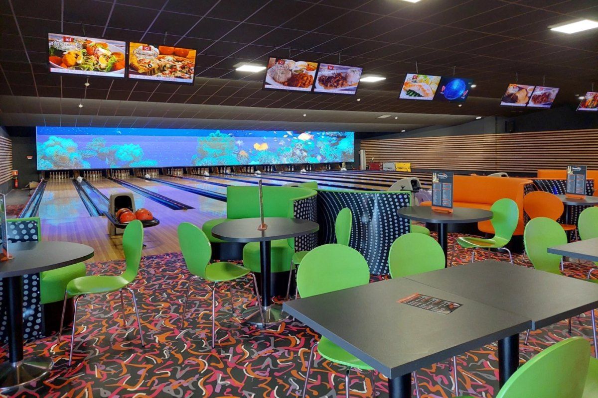 The bowling lanes and bright seating area inside Warm'up Bowling in Cannes La Bocca