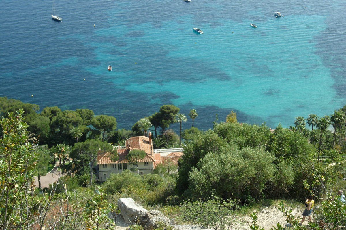 Turquoise sea, anchored boats and a red-roofed villa seen from the Chemin de Nietzsche above Èze-sur-Mer