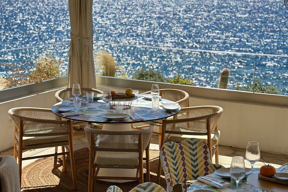 A round table set for lunch on a terrace of La Pinède, looking straight out over the glittering sea at Cap-d'Ail