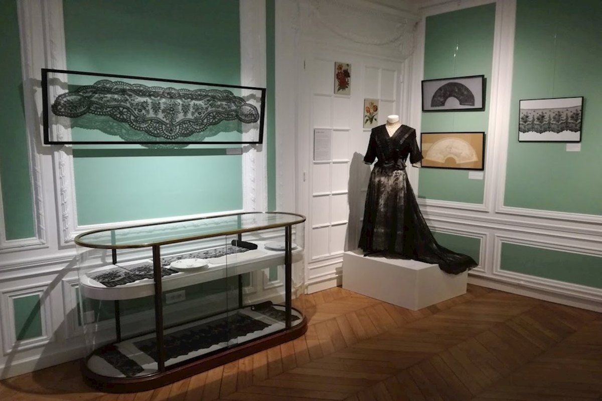 Black Chantilly lace shawls and a lace gown in a gallery of the Musée de la Dentelle