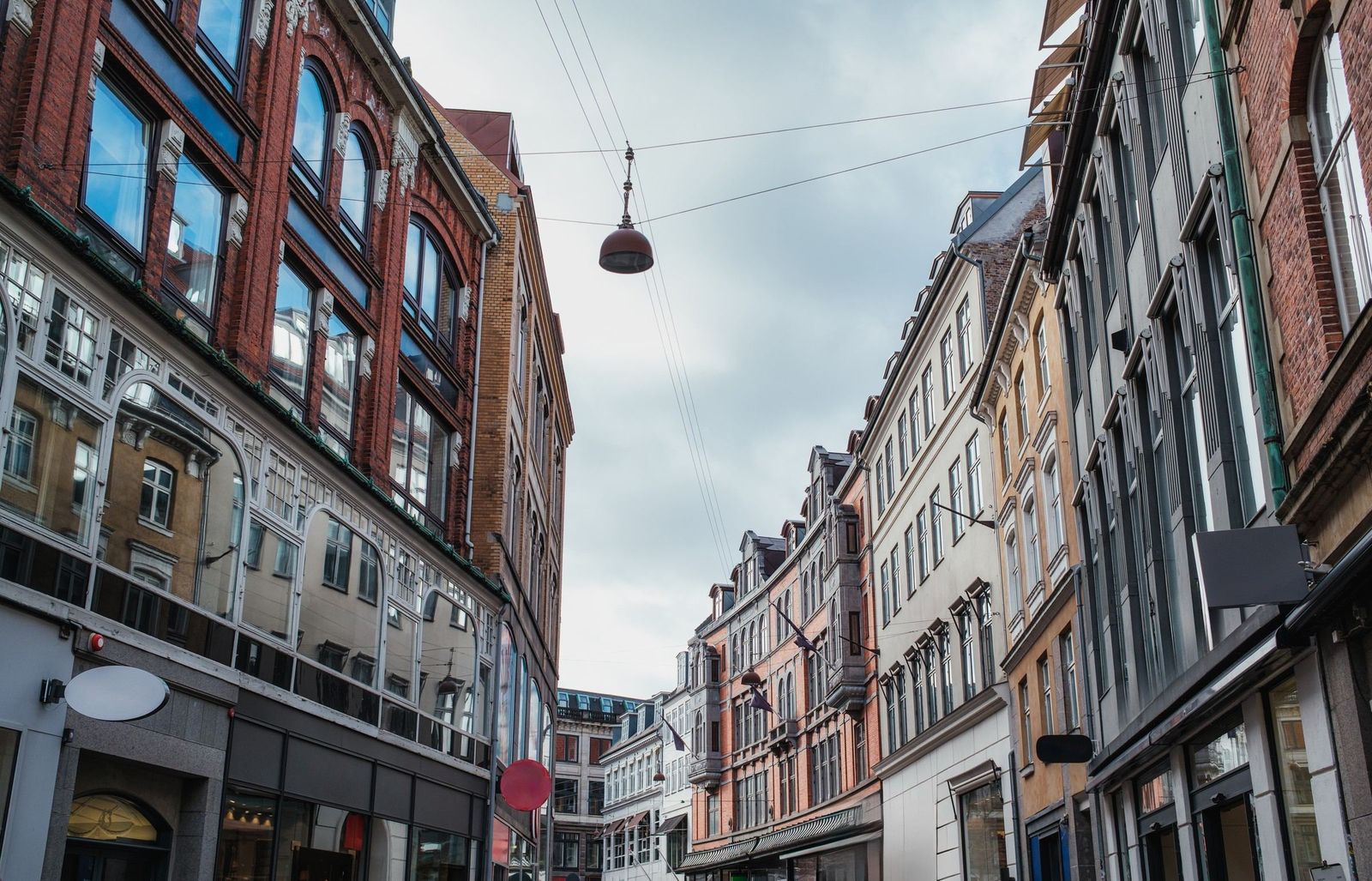 An old street in central Copenhagen with a lamp hung across it