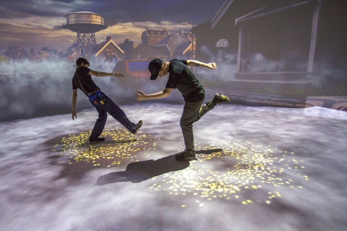 Two visitors dancing on an interactive light floor inside Experimentarium in Hellerup