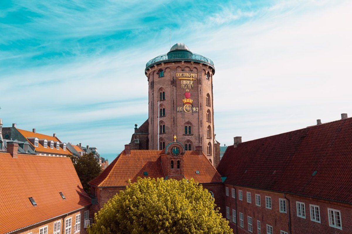 The Round Tower rising above the red-tiled roofs of central Copenhagen under a blue sky