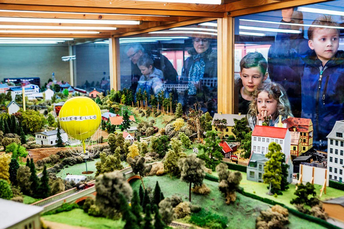 Children pressing up to the glass of a large model railway landscape at the Danish Museum of Science and Technology
