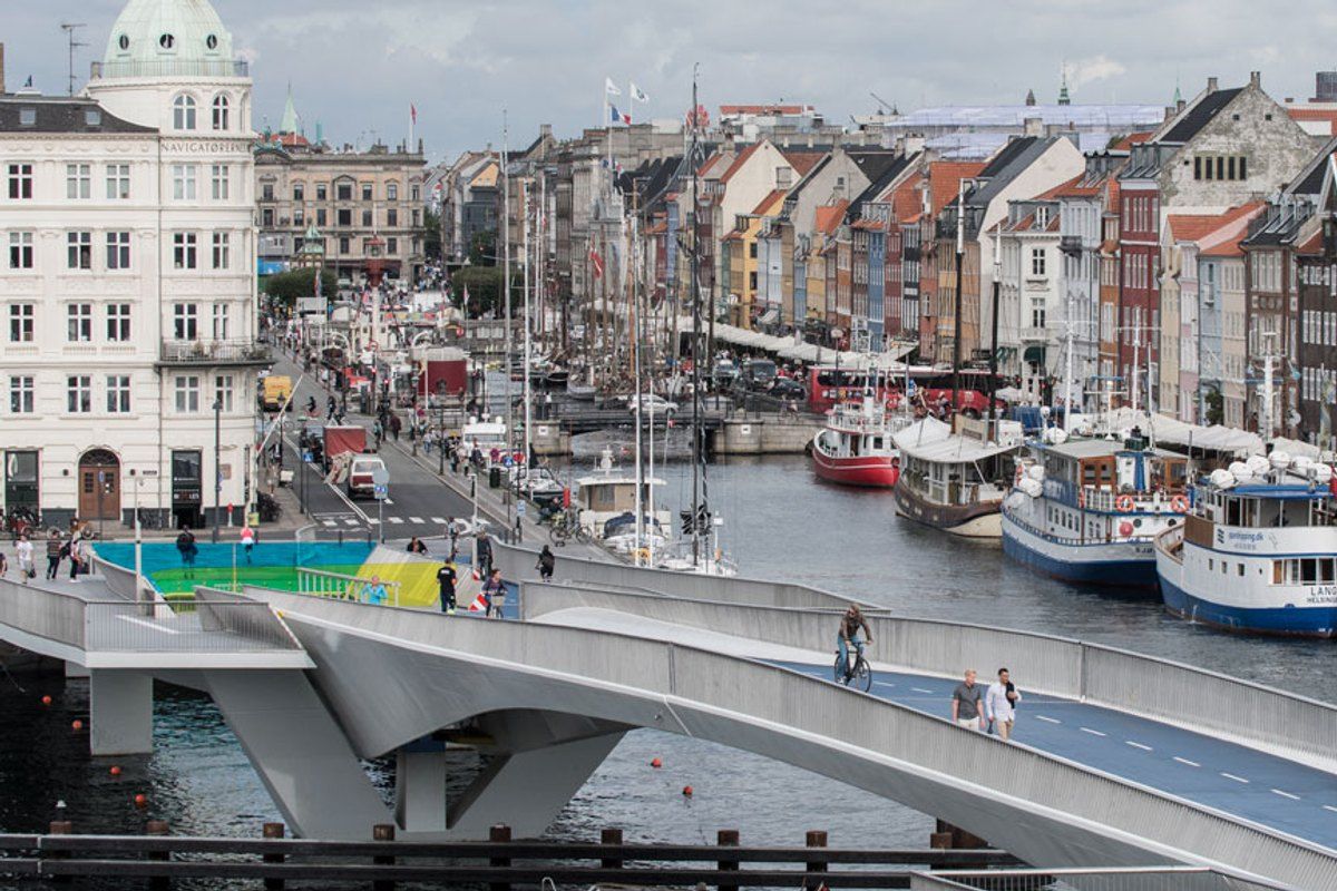 The Inner Harbour Bridge curving towards Nyhavn's coloured houses and moored boats