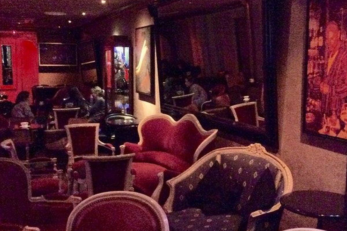 Red velvet armchairs and paintings in the lounge of the bar Aux Grognards, Fontainebleau