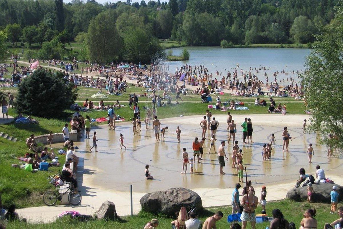 Families on the sandy beach and paddling pool by the lake at the Île de loisirs de Bois-le-Roi