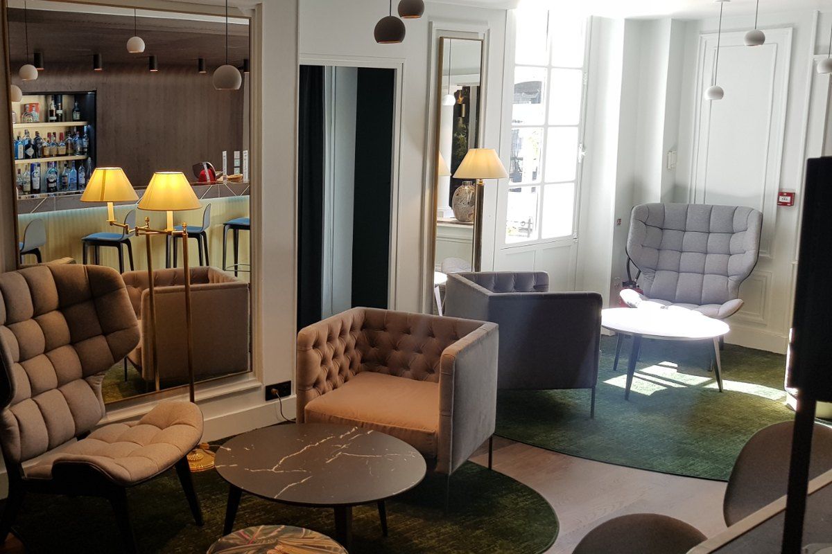 Quilted armchairs, low tables and the bar of Le Montijo at the Hôtel de l'Aigle Noir, Fontainebleau