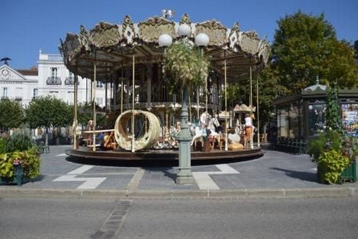 The ornate 1900-style wooden-horse carousel on a square in Fontainebleau