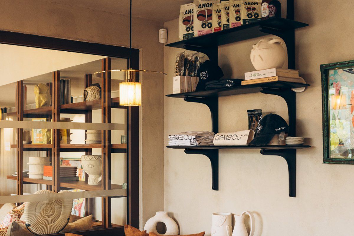 Shelves of ceramics, cushions and books in the lounge corner of the Bambou Café, Gassin