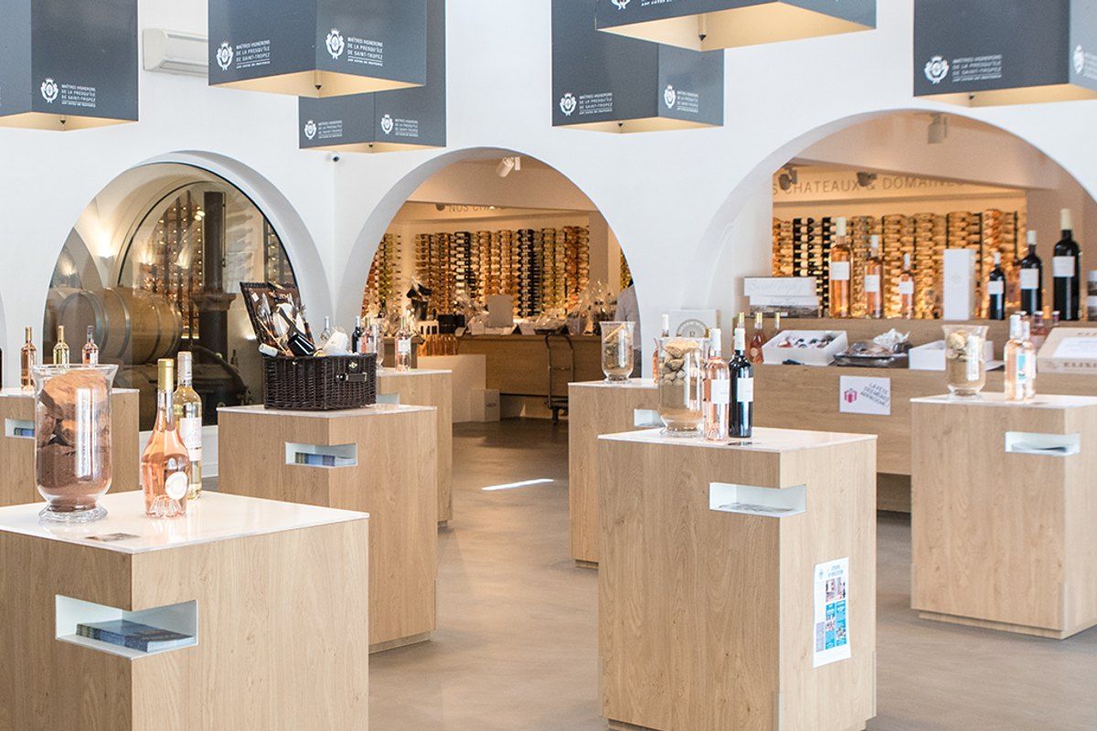 Bottles displayed on wooden plinths under the arches of the Maîtres Vignerons de la Presqu'île de Saint-Tropez shop