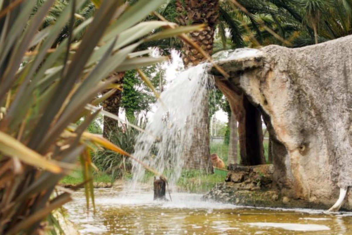 A waterfall over rocks among palms on the mini-golf course at La Palmeraie, Cogolin