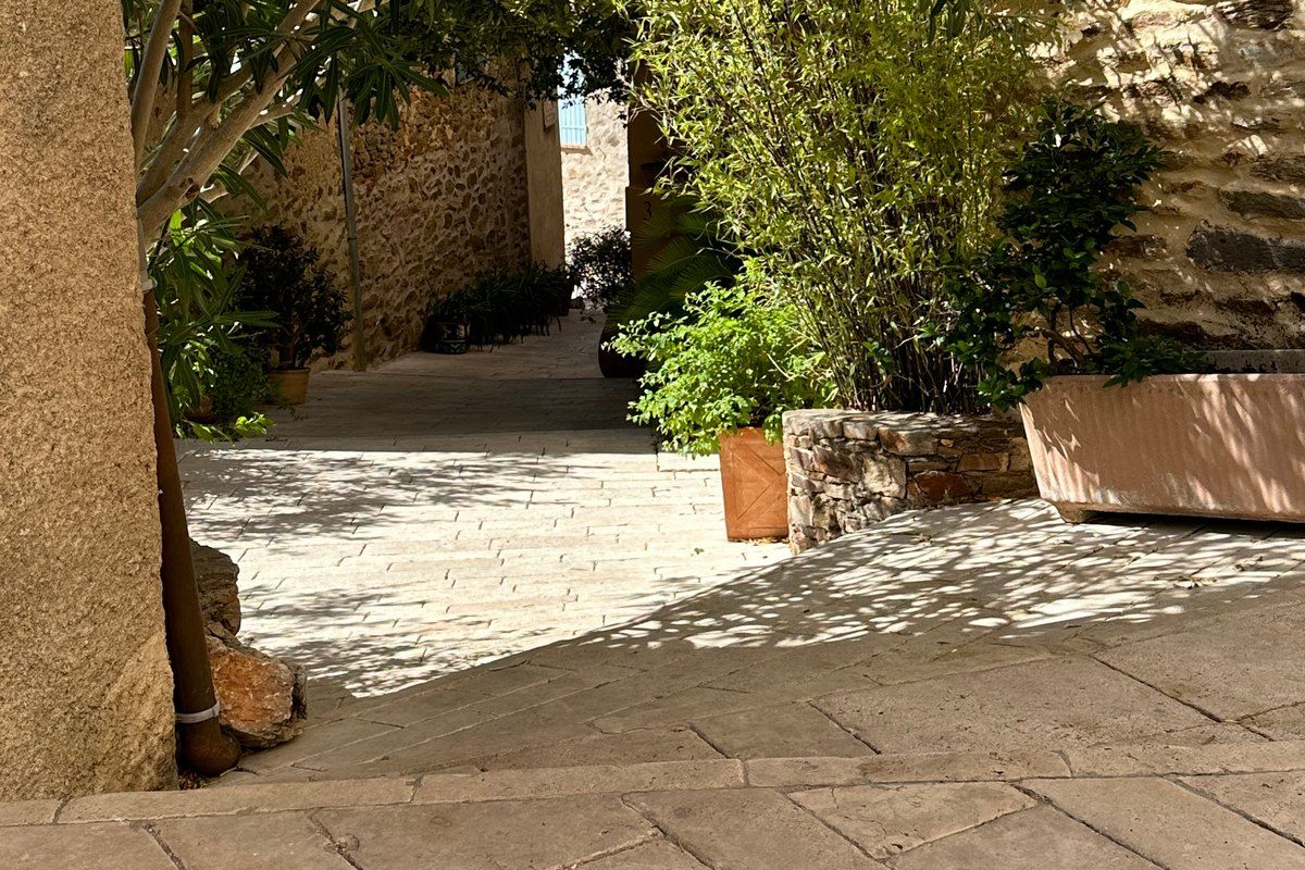 A shaded paved lane under an arch in the old village of Gassin