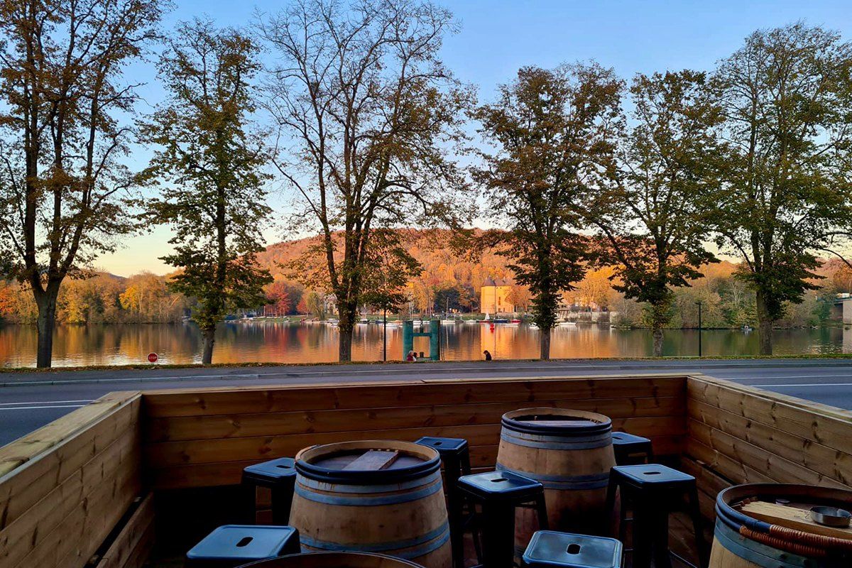 Barrel tables on La Belle Équipe's terrace facing the Seine at Vernon