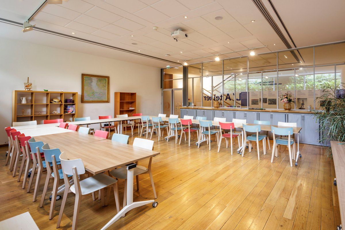The light-filled workshop room with long tables and coloured chairs at the Musée des impressionnismes Giverny