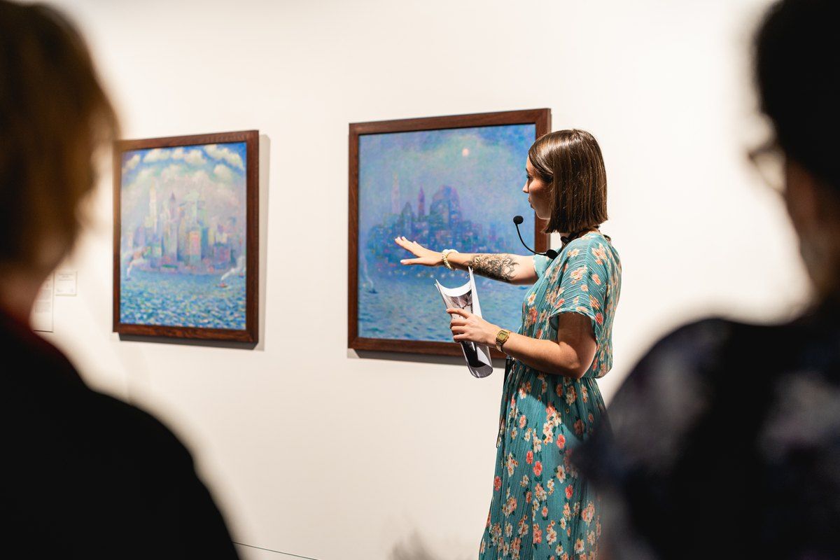A guide talking visitors through Impressionist paintings in the galleries of the Musée des impressionnismes Giverny