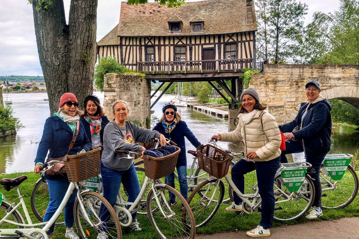 A group of cyclists with basket bikes by the Vieux-Moulin of Vernon