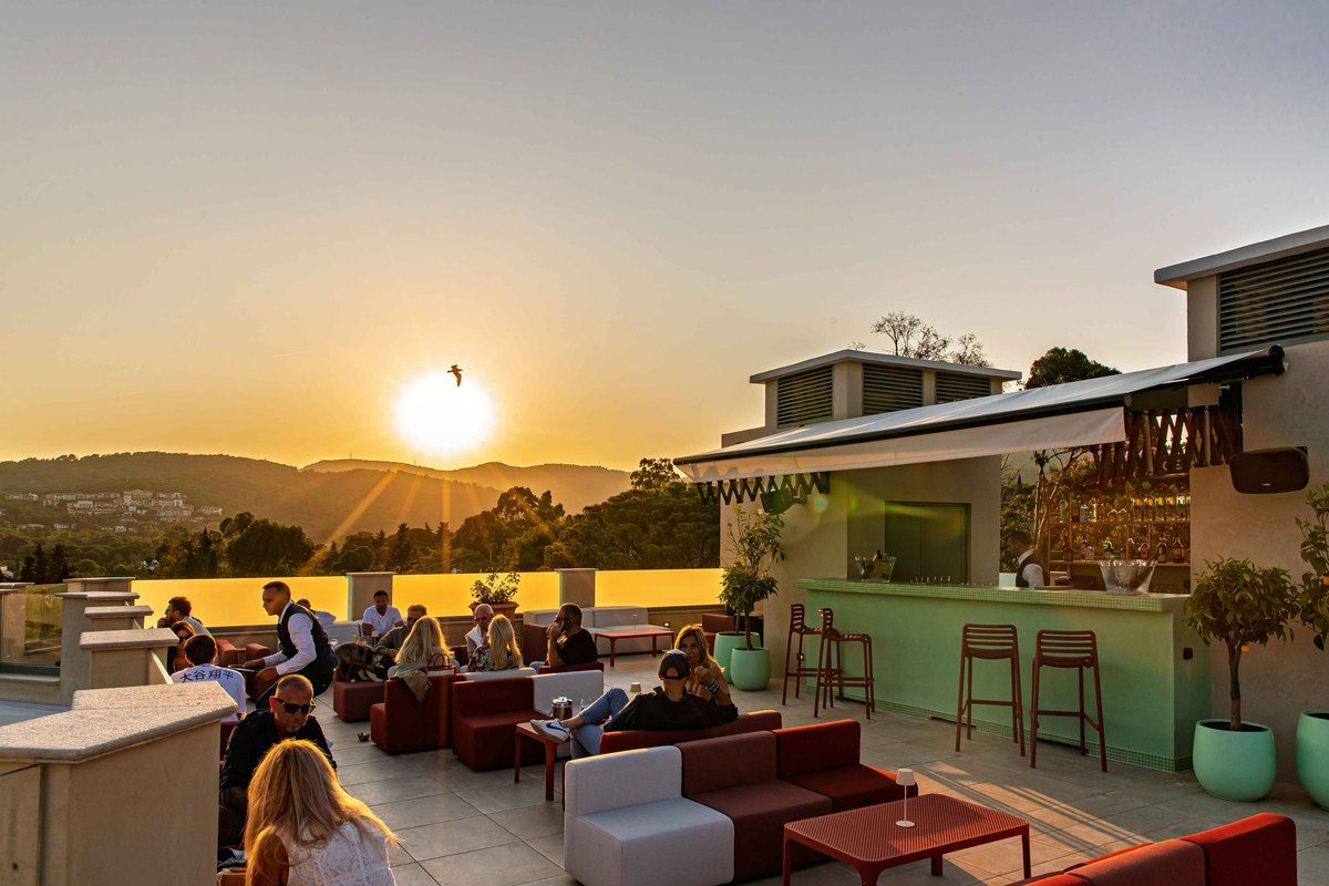 The sun setting over the hills behind the rooftop terrace and bar of the Château Rose in Grimaud