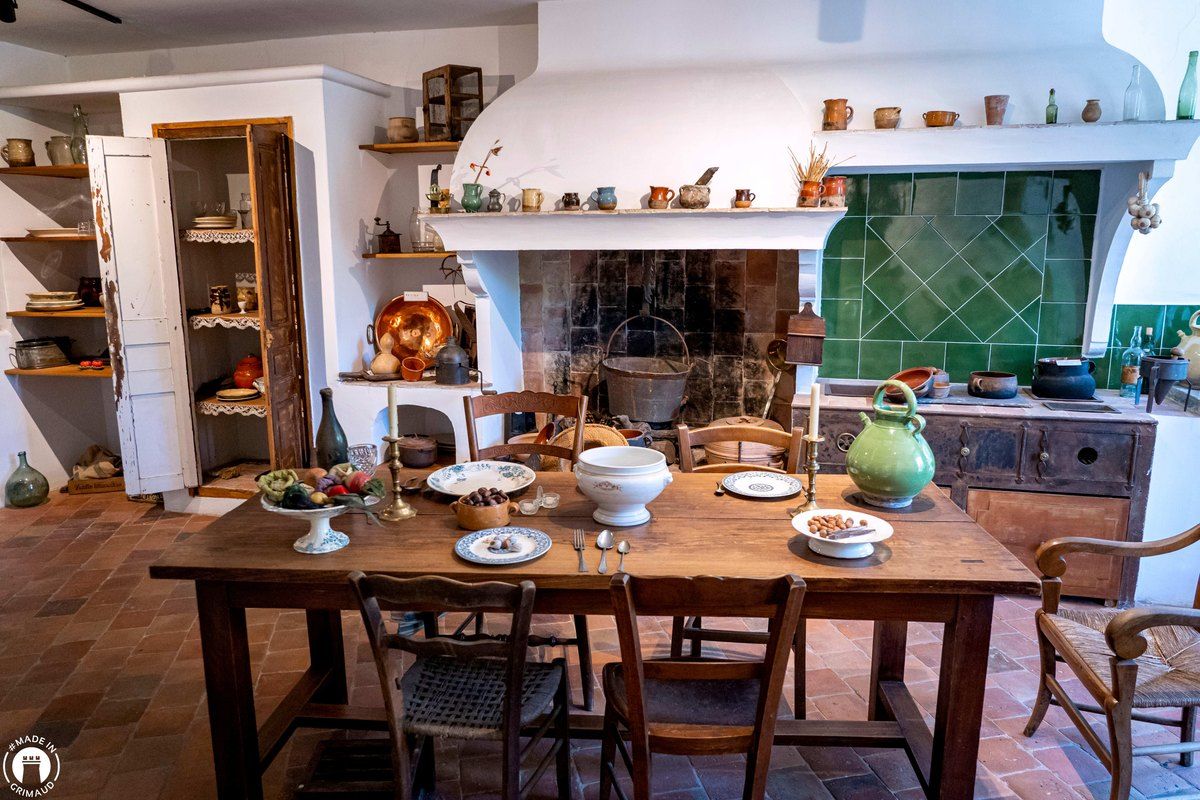 An old Provençal kitchen with a laid table and earthenware jugs at the Musée du Patrimoine in Grimaud