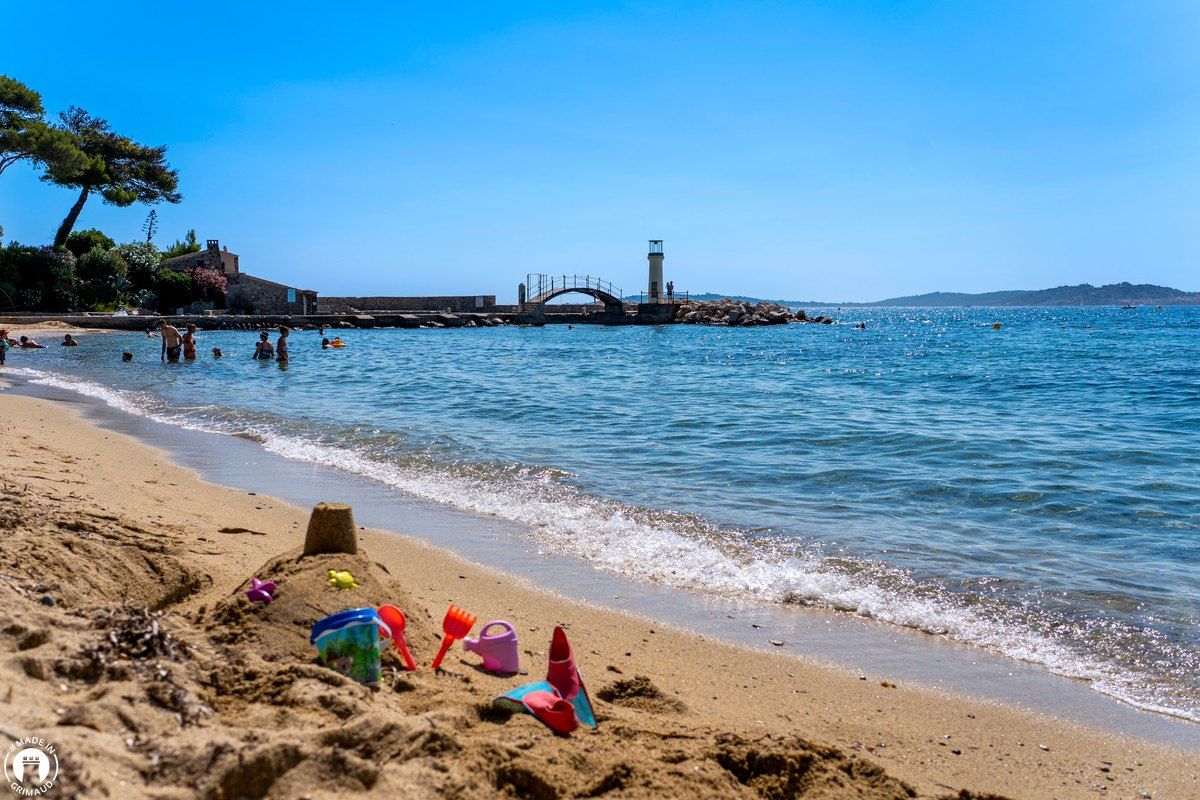 Sandcastle toys on the Plage des Cigales, with the little lighthouse and footbridge at the end of the jetty