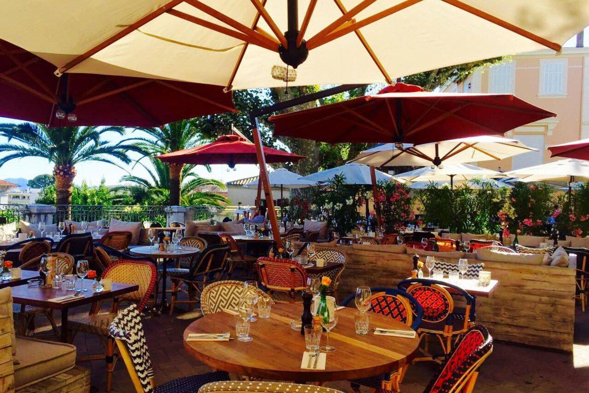 Tables under red and white parasols on the terrace of L'Atelier Joseph, Place Bellevue, Le Cannet