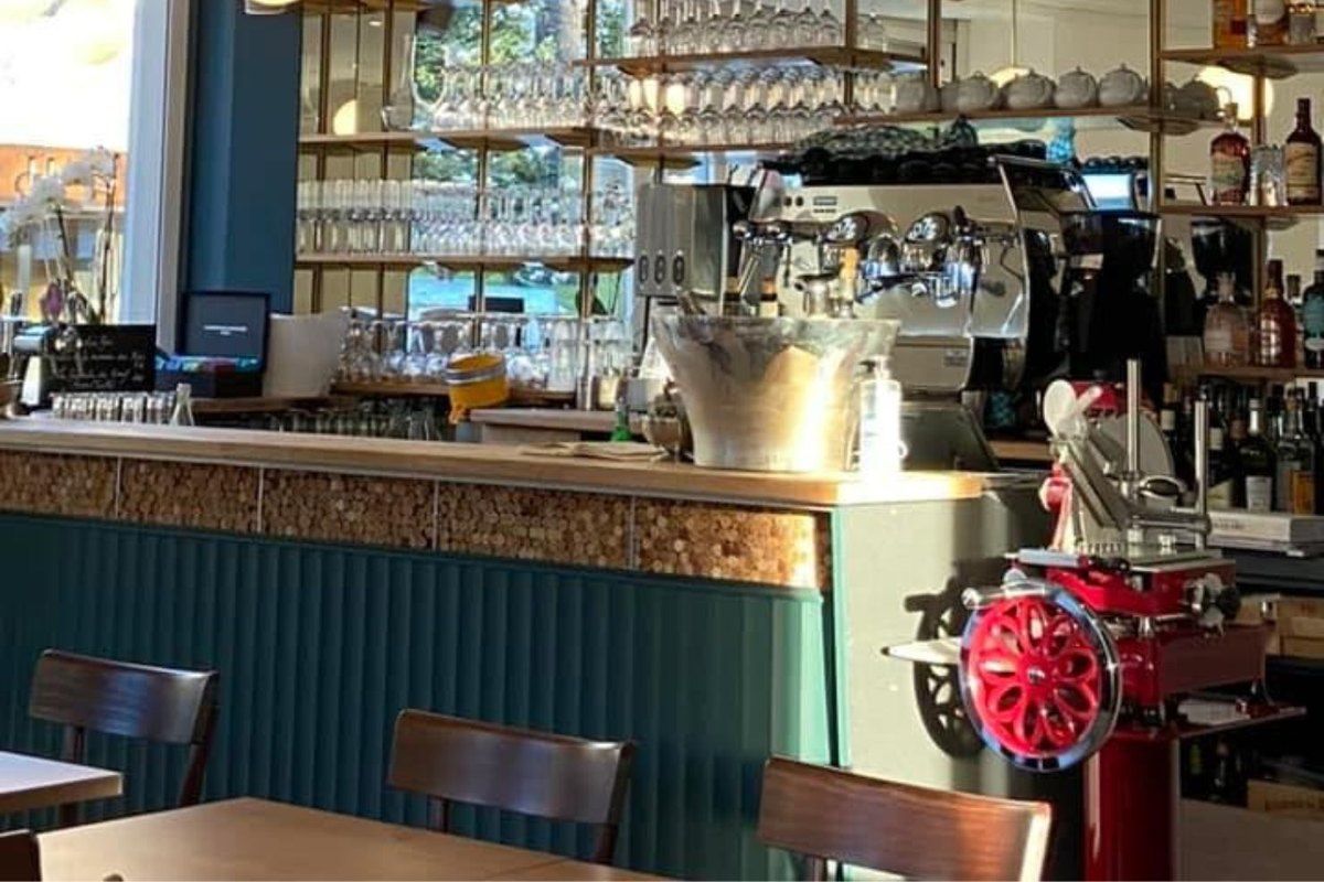 The bar counter of Racine on boulevard Sadi Carnot, with a red slicer and shelves of glasses