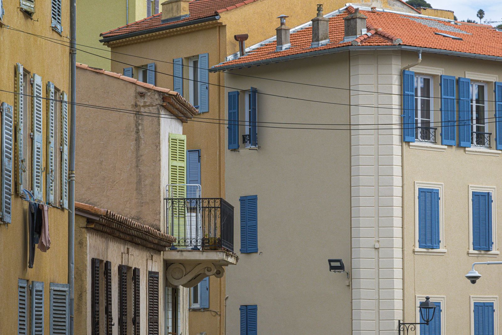 Houses with blue shutters on a street in Le Cannet