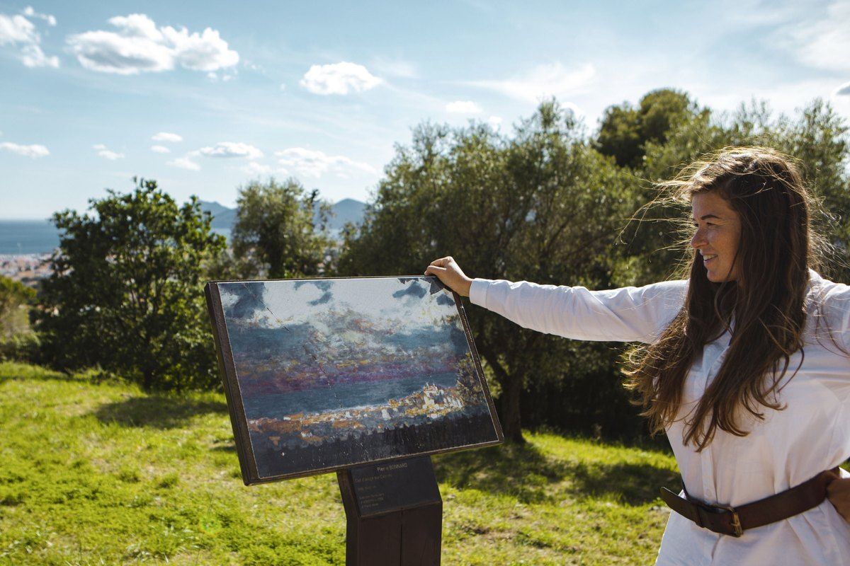 A walker at one of the lecterns of the 'Sur les pas de Bonnard' trail, comparing Bonnard's painting with the view