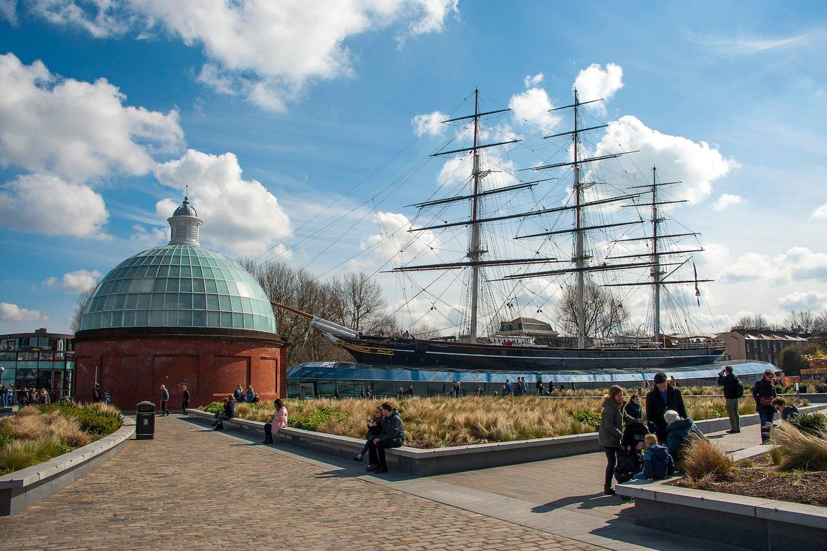 The masts and rigging of Cutty Sark in dry dock in Greenwich, beside the domed entrance to the foot tunnel