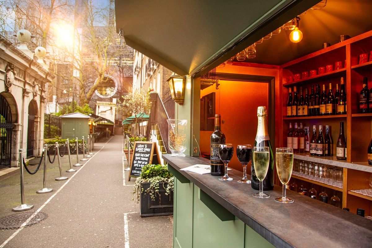 The outdoor wine hut and tables of Gordon's Wine Bar on Watergate Walk, Embankment