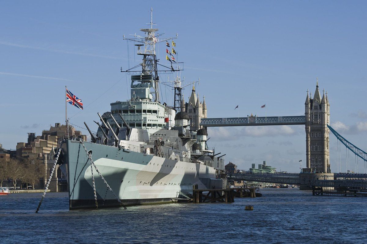 HMS Belfast moored on the Thames with Tower Bridge behind