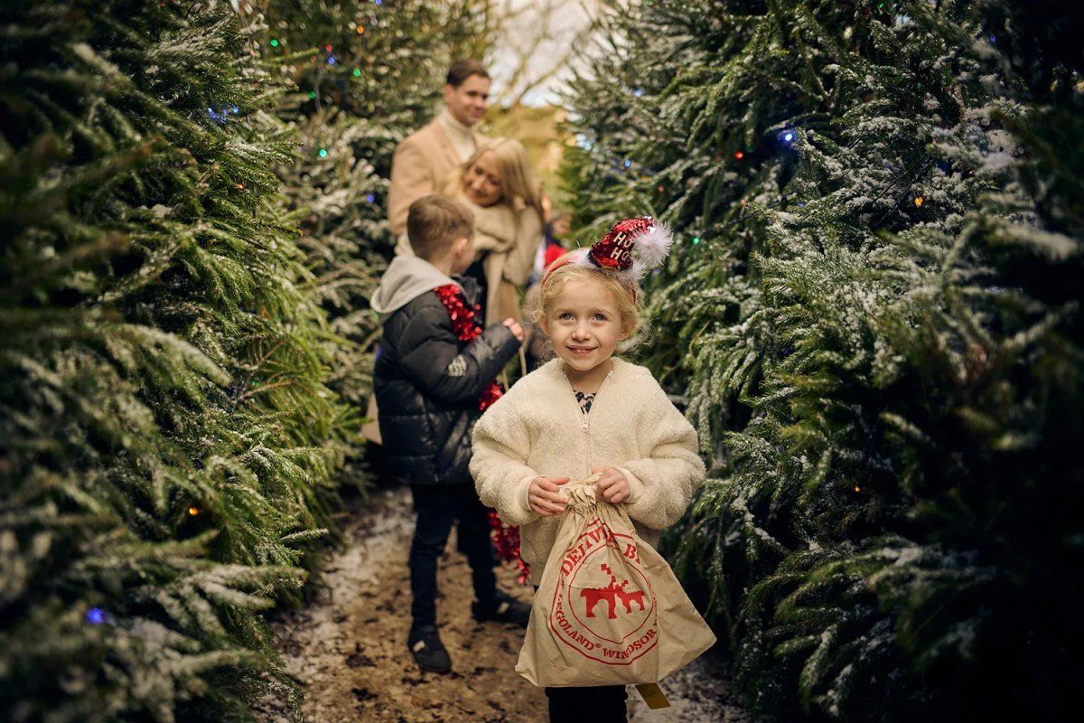 A girl with a Santa sack walking between frosted Christmas trees at LEGOLAND Windsor at Christmas