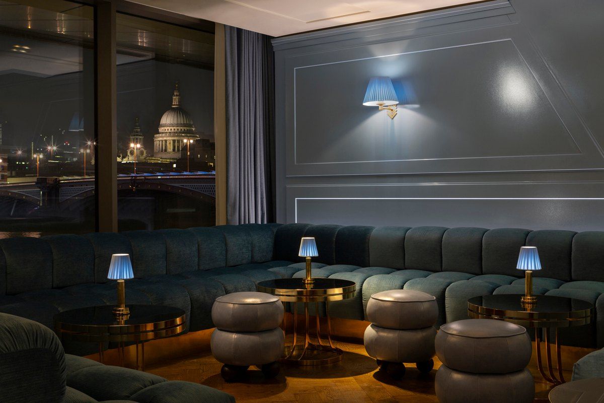 Blue lounge seating at Lyaness looking out over the Thames to St Paul's Cathedral at night