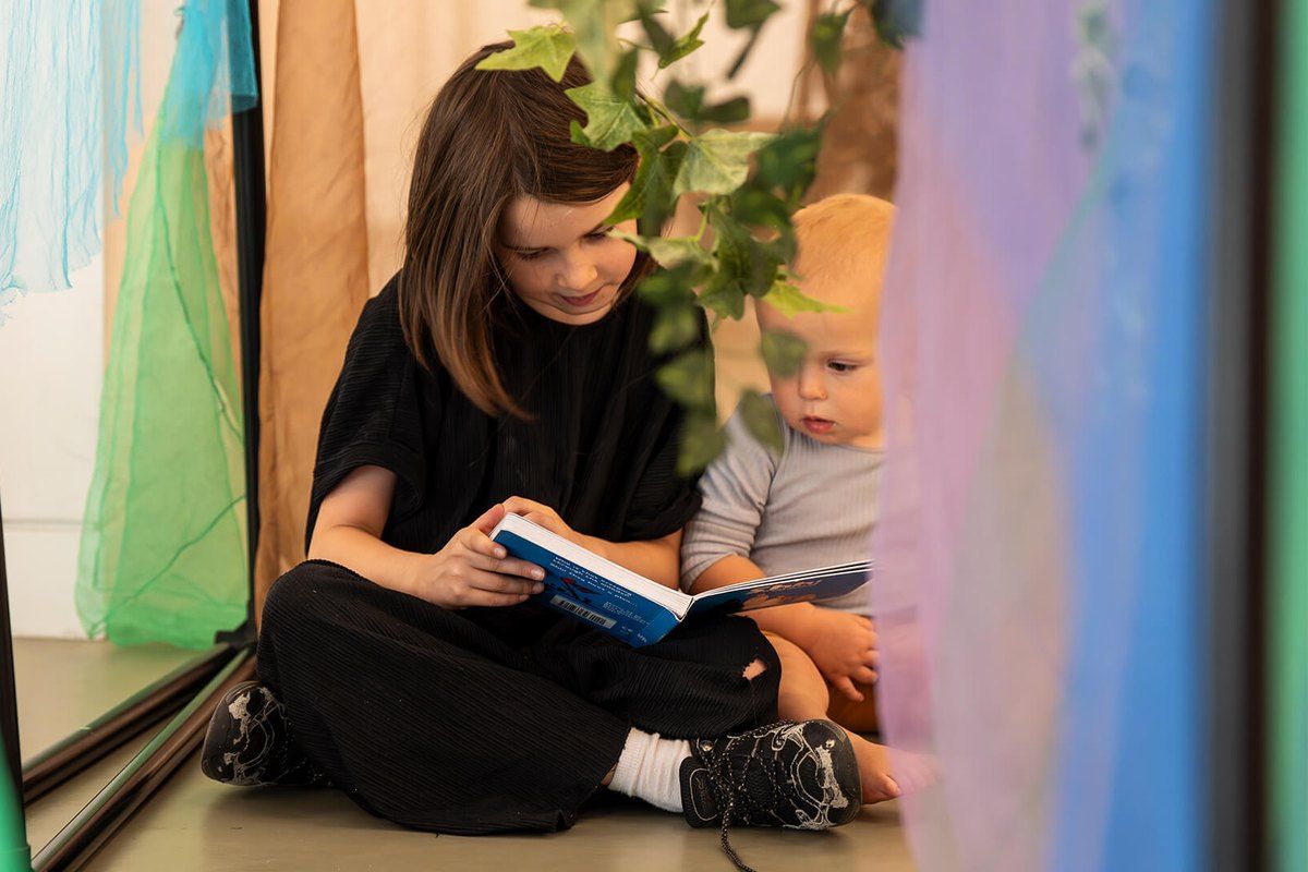 Two children reading a picture book together in the family Social Space at the National Gallery