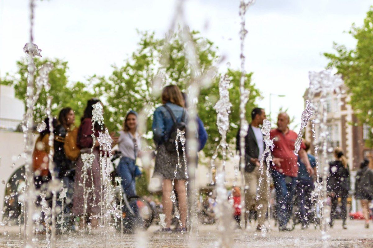 Walkers seen through the jets of a fountain off the King's Road in Chelsea
