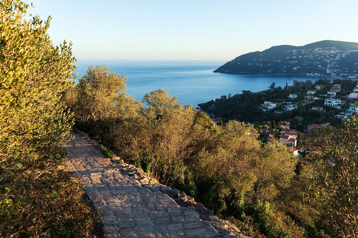 A paved path through the maquis on Mont San Peyre, with the sea and the Estérel coast below