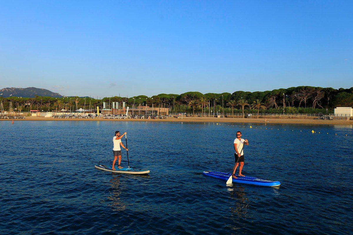 Two paddleboarders on calm water in the bay of La Napoule