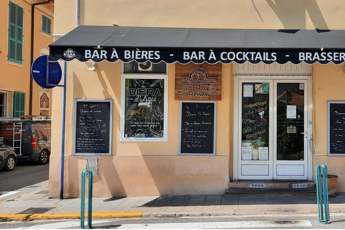 The shopfront of Biera d'Aqui beer and cocktail bar on avenue Cernuschi, Menton, with chalkboard menus