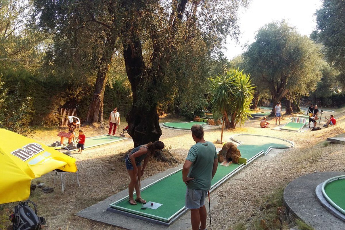 Families playing on the 18-hole Mini Golf du Pian among the old olive trees of the Parc du Pian, Menton