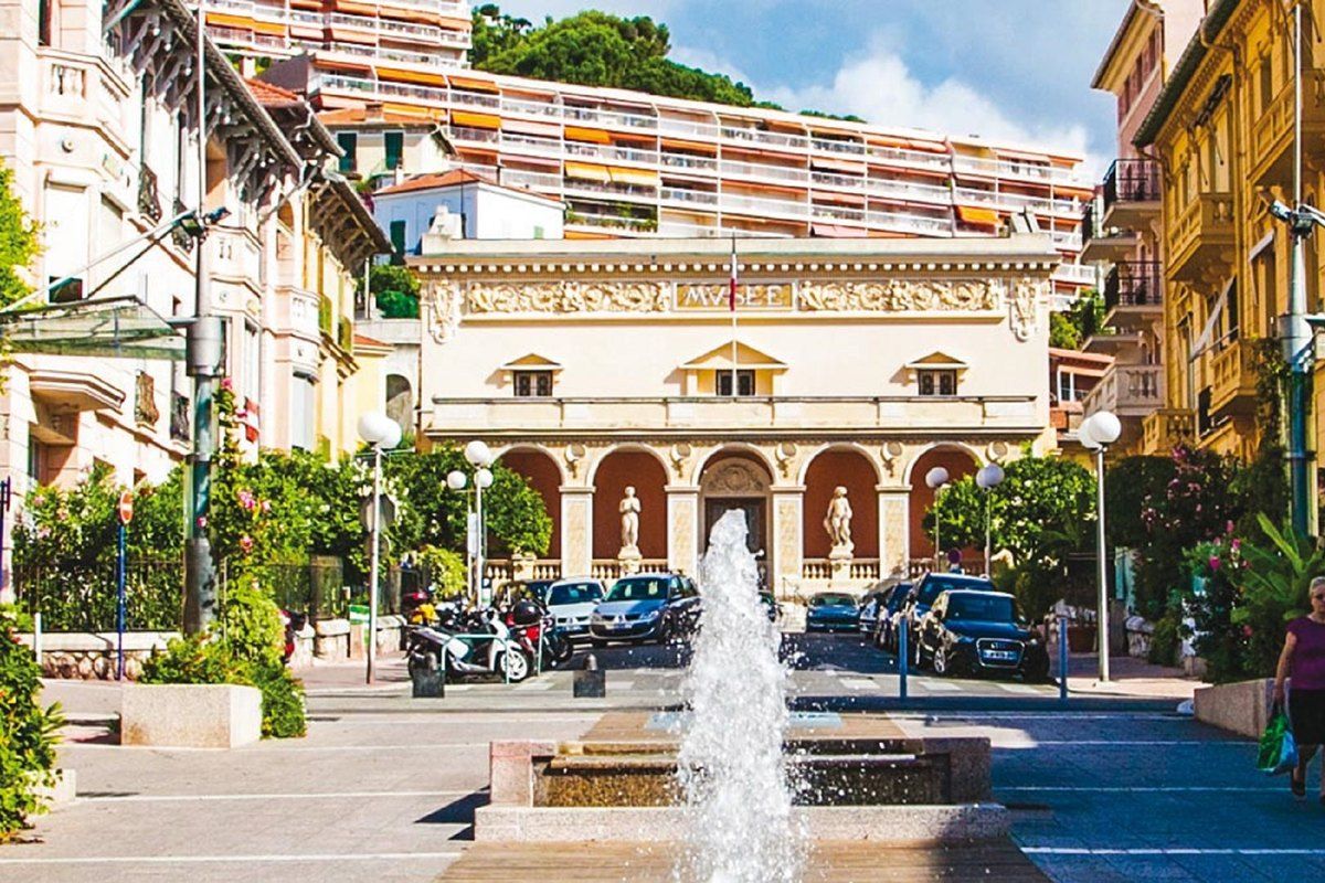 The arcaded façade of the Musée de Préhistoire Régionale in Menton with a fountain in front