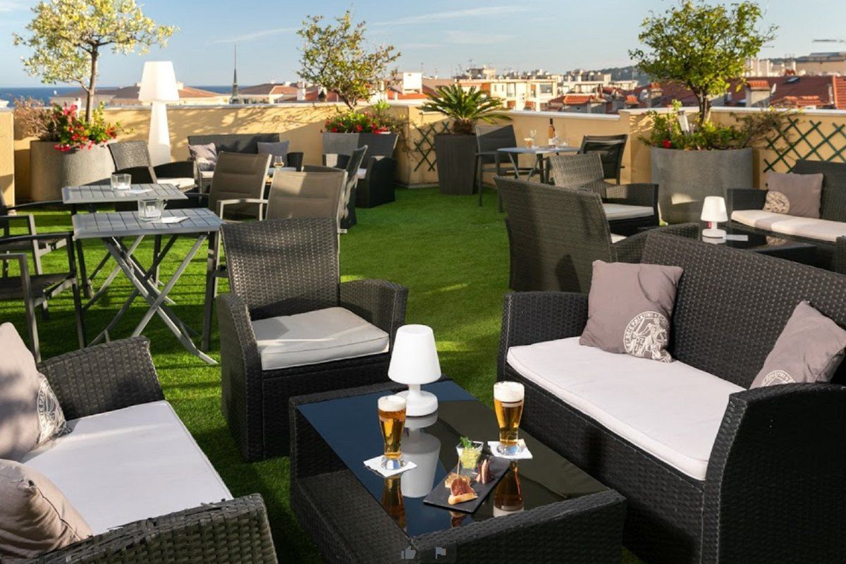 Lounge sofas, lamps and two beers on the seventh-floor rooftop terrace of the Hôtel Méditerranée in Menton