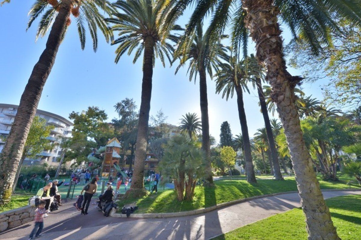 Palm-shaded lawns and the playground of Square Fernandez in Menton's Carnolès quarter