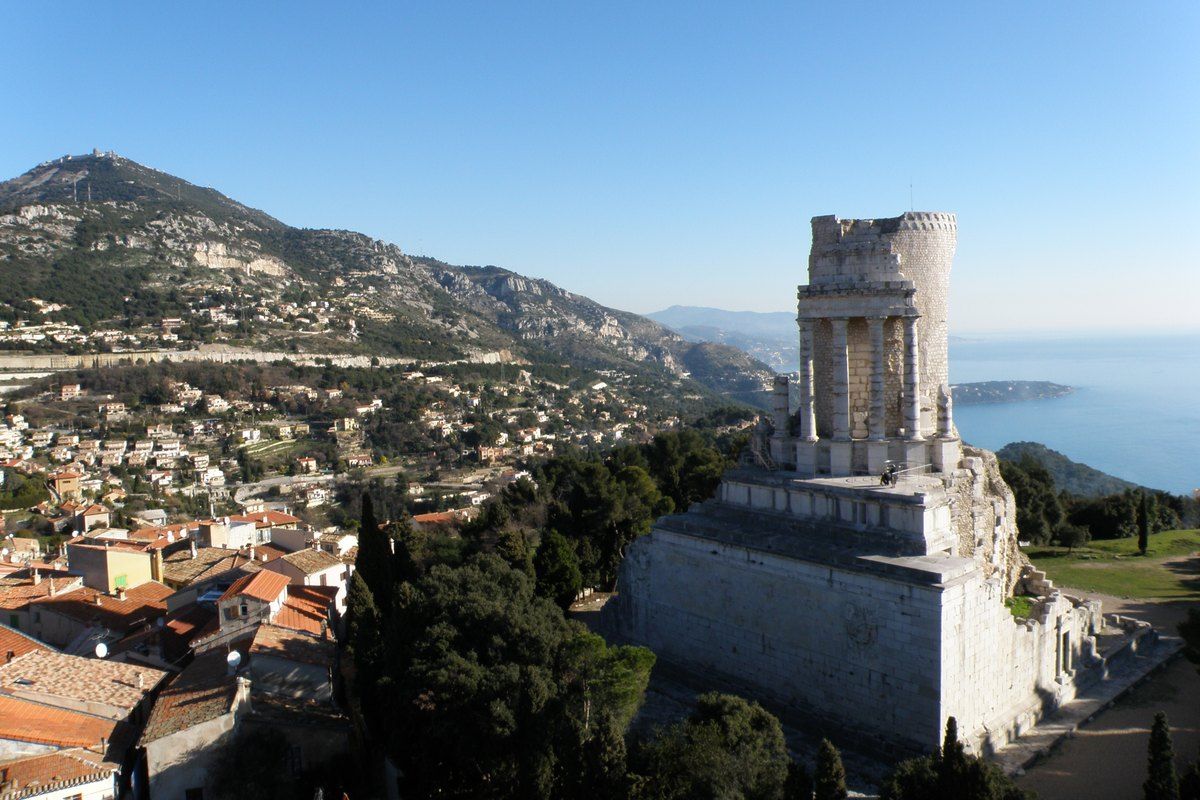 The Roman Trophée d'Auguste above the rooftops of La Turbie, with the sea and the Riviera coast beyond