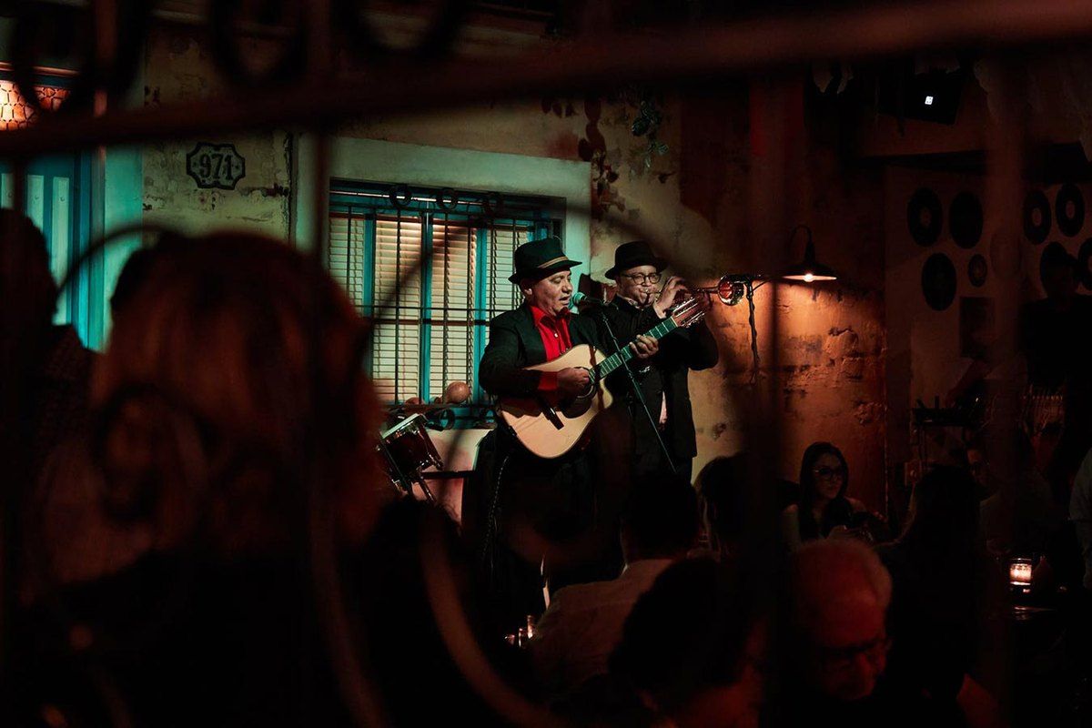 Trova musicians playing guitar on the small stage of Cafe La Trova in Little Havana