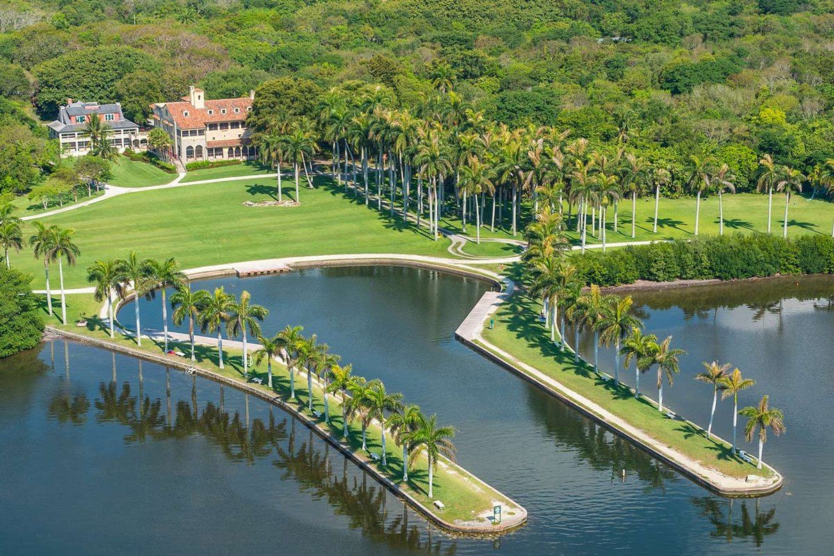 Aerial view of the Deering Estate houses, palm-lined boat basin and lawns on Biscayne Bay