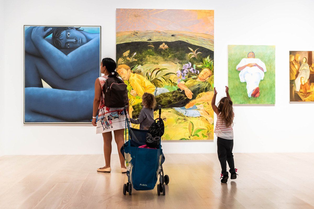 A mother with a pushchair and a child pointing at large colourful paintings in a gallery at ICA Miami